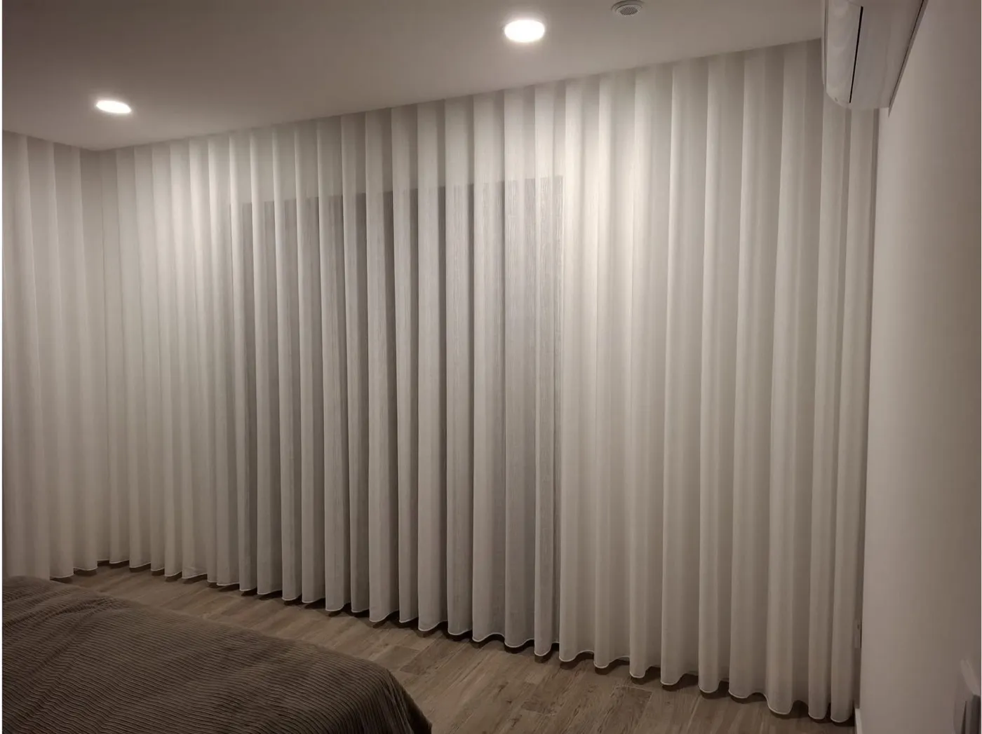 Cortinados à medida a cobrir a parede de um quarto, confecionados pela Decor Style
