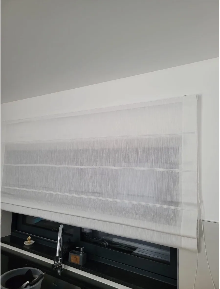 Estore de tecido claro recolhido em pregas sobre a janela de uma cozinha, aplicado pela Decor Style